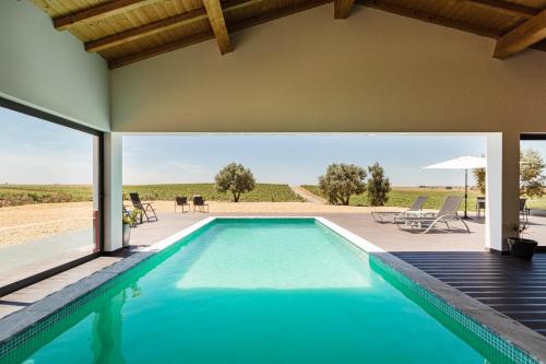 an indoor pool with a view of a house at Fontes Bárbaras Enoturismo in Entradas