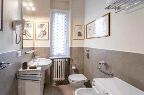 baño con lavabo y aseo y ventana en Casa Vacanze In Arte Milano, en Milán
