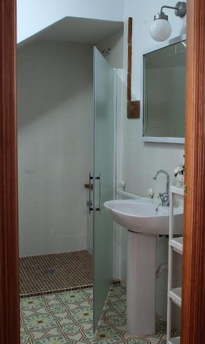 a bathroom with a sink and a shower with a mirror at El Barranquillo in Cazalla de la Sierra