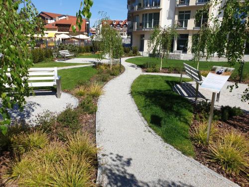 a park with two benches and a walkway at Hotel White in Krynica Morska