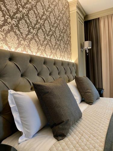 a bedroom with a large bed with pillows on it at Hotel Villa Malpensa in Vizzola Ticino