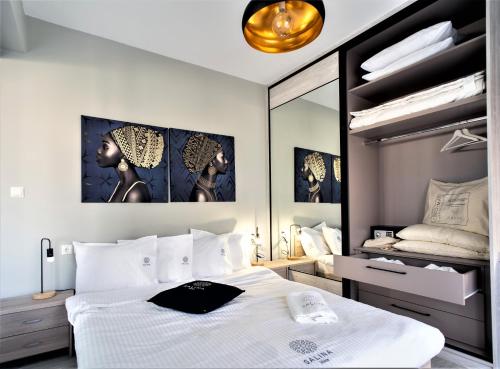 a bedroom with a white bed and a mirror at Salina Premium Residences Volos in Volos