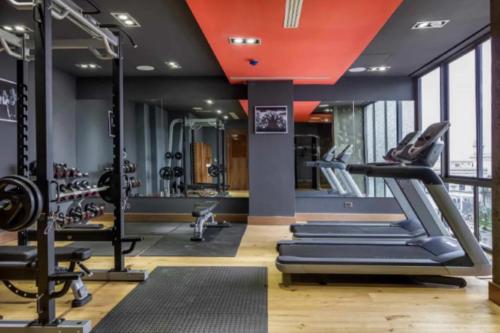 a gym with treadmills and ellipticals and a red ceiling at Eden Place in Lagos