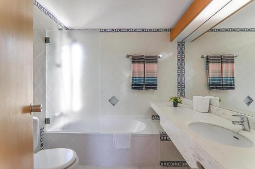 Un baño con bañera, lavabo e inodoro. en Apartment Dansk, en Quinta do Lago