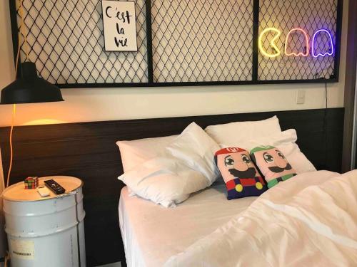 ein Zimmer mit einem Bett mit zwei Kissen und einem Schild in der Unterkunft Granja Viana Studio 429 decoracao industrial in Cotia