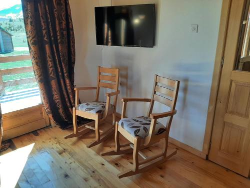 two wooden chairs sitting in a room with a tv at Zabljak Holiday in Žabljak