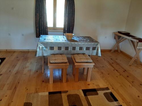 a table with two stools and a table with a glass top at Zabljak Holiday in Žabljak