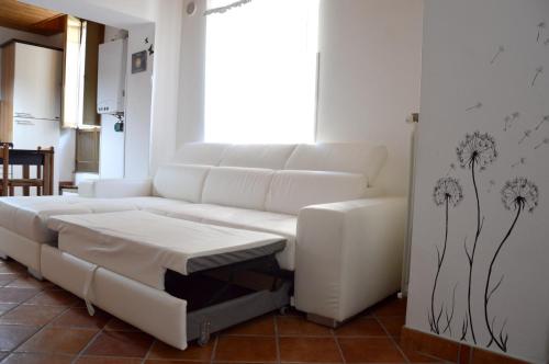 a living room with a white couch and dandelion mural at Cozy apartment in Caltagirone - 70 m² with balcony in Caltagirone