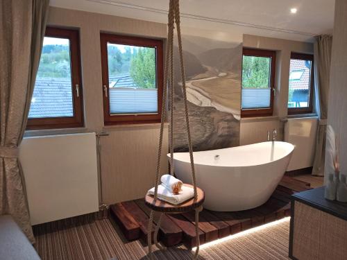 ein Badezimmer mit einer Badewanne und einem Wandgemälde in der Unterkunft Flair Hotel Werbetal in Waldeck