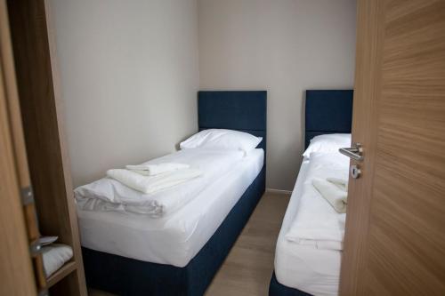 two twin beds in a small room with blue headboards at SALAMANDRA Hotel in Banská Štiavnica