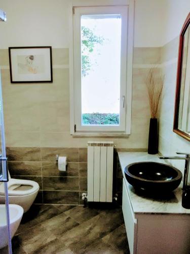 a bathroom with a sink and a toilet and a window at Villa Relax in Stresa