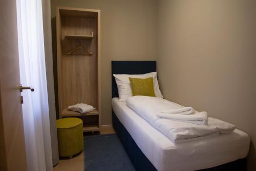 a small bedroom with a bed with white sheets at SALAMANDRA Hotel in Banská Štiavnica