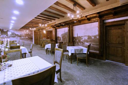 un restaurant avec des tables et des chaises dans une salle dans l'établissement Hotel Happy, à Gjakove