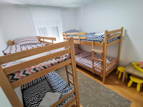 a bedroom with two bunk beds and a table at Drinska kućica in Ljubovija