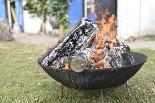 a grill with a fire in it in the grass at Skortskær Bondegårdsferie in Havnsø