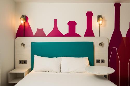 a bedroom with a bed with vases on the wall at ibis Styles Barnsley in Barnsley