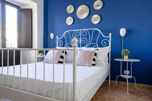 1 dormitorio con 1 cama con pared azul en Palazzo Currò, en Catania