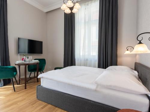 a bedroom with a bed and a table and a tv at VacationClub – Wisus Apartament 19 in Świnoujście