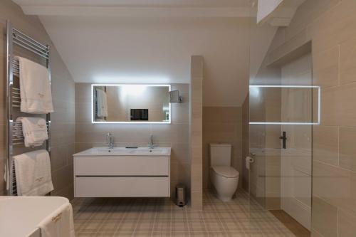 a bathroom with a sink and a toilet and a mirror at Farlam Hall Hotel & Restaurant in Brampton