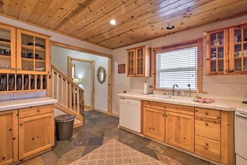 a kitchen with wooden cabinets and a sink at Rockaway Beach Hideaway with Hot Tub and Fireplace! in Rockaway Beach