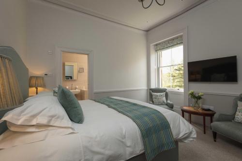a bedroom with a large bed and a window at Farlam Hall Hotel & Restaurant in Brampton