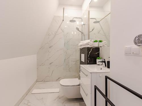 bagno bianco con servizi igienici e doccia di VacationClub – Wisus Apartament 28 a Świnoujście