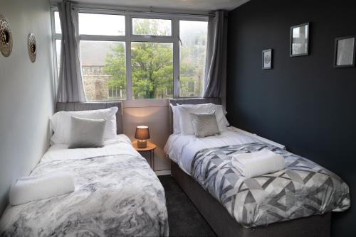 dwa łóżka w pokoju z oknem w obiekcie Large Modern Contractor House - FREE Parking - Staycations Welcome w mieście Northfleet