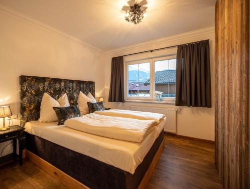a bedroom with a large bed and a window at Ferienwohnungen Jägerheim & Jägerhaus in Ehrwald