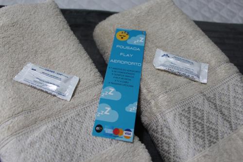 two packets of toothpaste sitting on top of a couch at Pousada Flay 7 minutos Próximo do Aeroporto de Florianópolis in Florianópolis