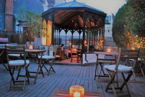 um gazebo com mesas e cadeiras num pátio em Sourire Boutique Hôtel Particulier em Paris