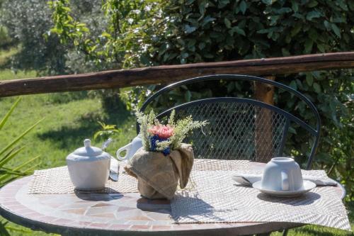 a table with a tea pot and flowers on it at Agriturismo Colleverde Capalbio in Capalbio