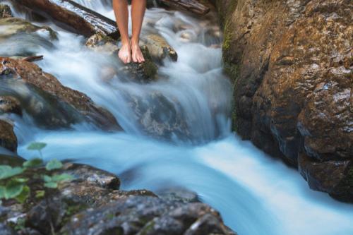 a person standing on the rocks in a stream at Chalet Mountain Plaza - Apt Greenvalley in Pinzolo