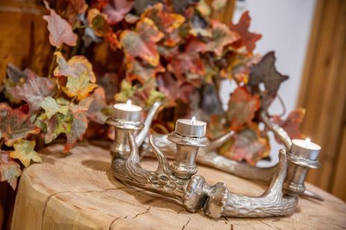 a candle holder with two candles on top of a table at Chalet Mountain Plaza - Apt Greenvalley in Pinzolo