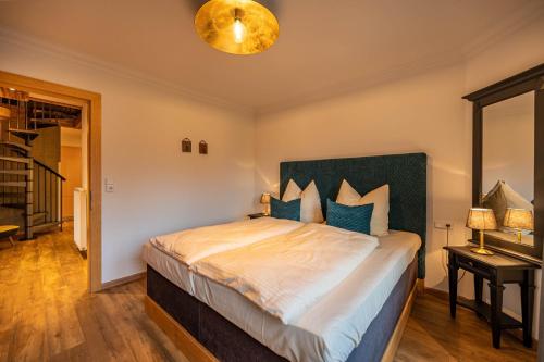 a bedroom with a large bed with blue pillows at Ferienwohnungen Jägerheim & Jägerhaus in Ehrwald