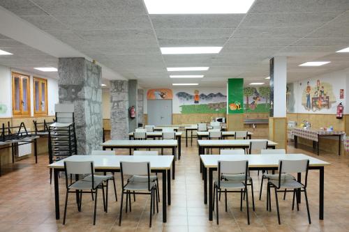 una clase con mesas y sillas en una cafetería en La Casa de Pineta, en Bielsa