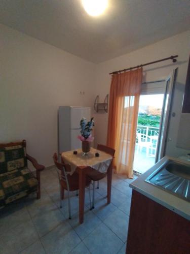 a kitchen with a small table and a refrigerator at Δειλινά in Plati