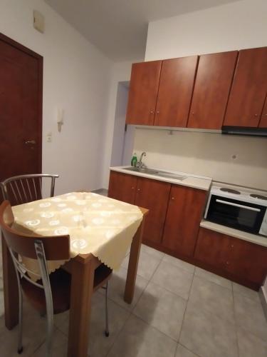 a kitchen with a table and a stove and cabinets at Δειλινά in Plati