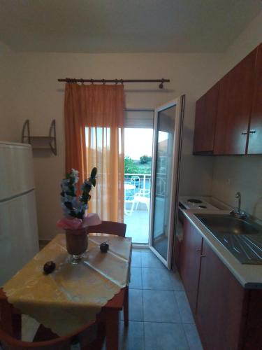 a kitchen with a small table and a kitchen with a window at Δειλινά in Plati