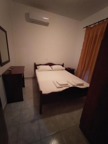a bedroom with a bed with white sheets and pillows at Δειλινά in Plati
