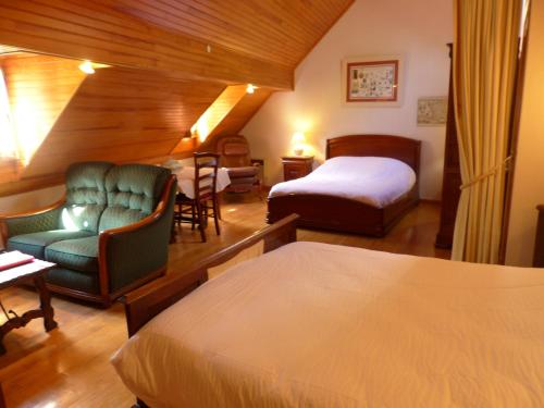 ein Hotelzimmer mit einem Bett, einem Bett und einem Stuhl in der Unterkunft LA Bouigane in Saint-Lary-Soulan