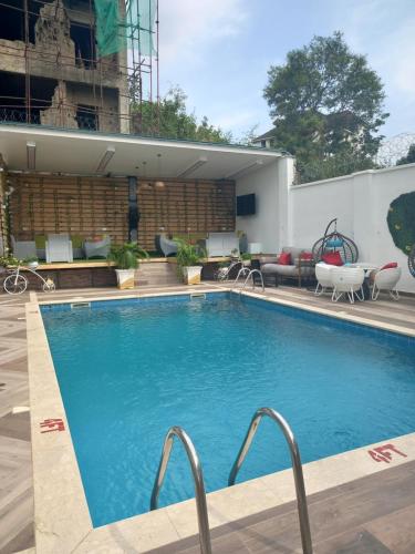a large swimming pool with chairs and a building at Prosbel Hotel in Abuja