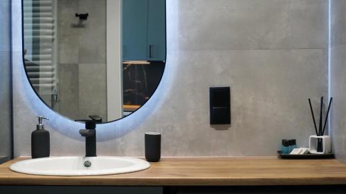 a bathroom with a sink and a large mirror at Apartament 47 Letnica in Gdańsk