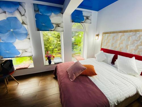 um quarto com uma cama grande e 2 janelas em MAREA NEAGRA Executive Rooms em Mamaia