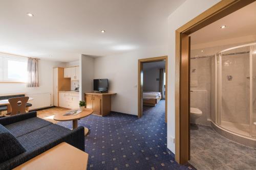 a hotel room with a couch and a shower at Petaunerhof in Schenna