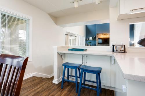 a kitchen with two blue stools at a counter at Wintergreen Retreat with Private Sauna & Patio 82291 in Blue Mountains