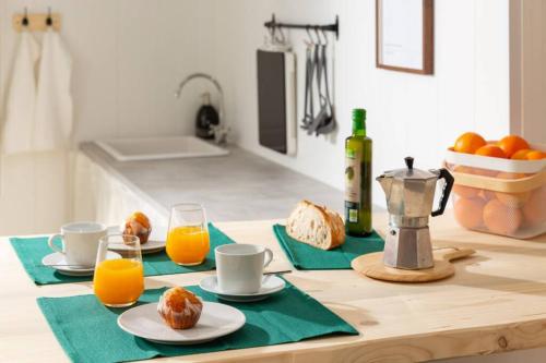 una mesa con dos tazas y dos vasos de zumo de naranja en La Casita de Piedra en Cercedilla