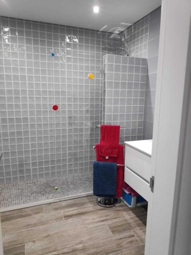 a bathroom with a shower with a red chair and a sink at Supertubos - Peniche - Consolação in Peniche