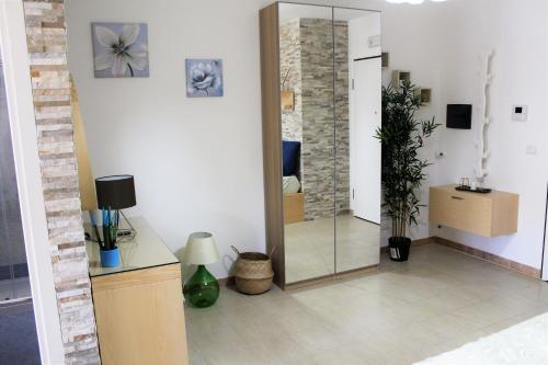 Casa Angelina Deluxe Suite في ليتشي: غرفة معيشة مع مرآة وخزانة