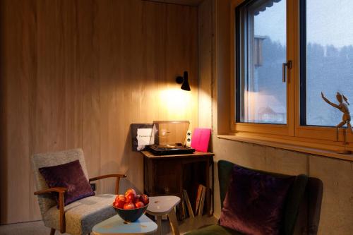 a room with a chair and a bowl of fruit on a table at Stud!o 8 in Bezau