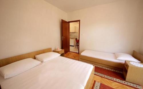 two beds in a room with a mirror at APARTMENTS Vuković in Vrboska